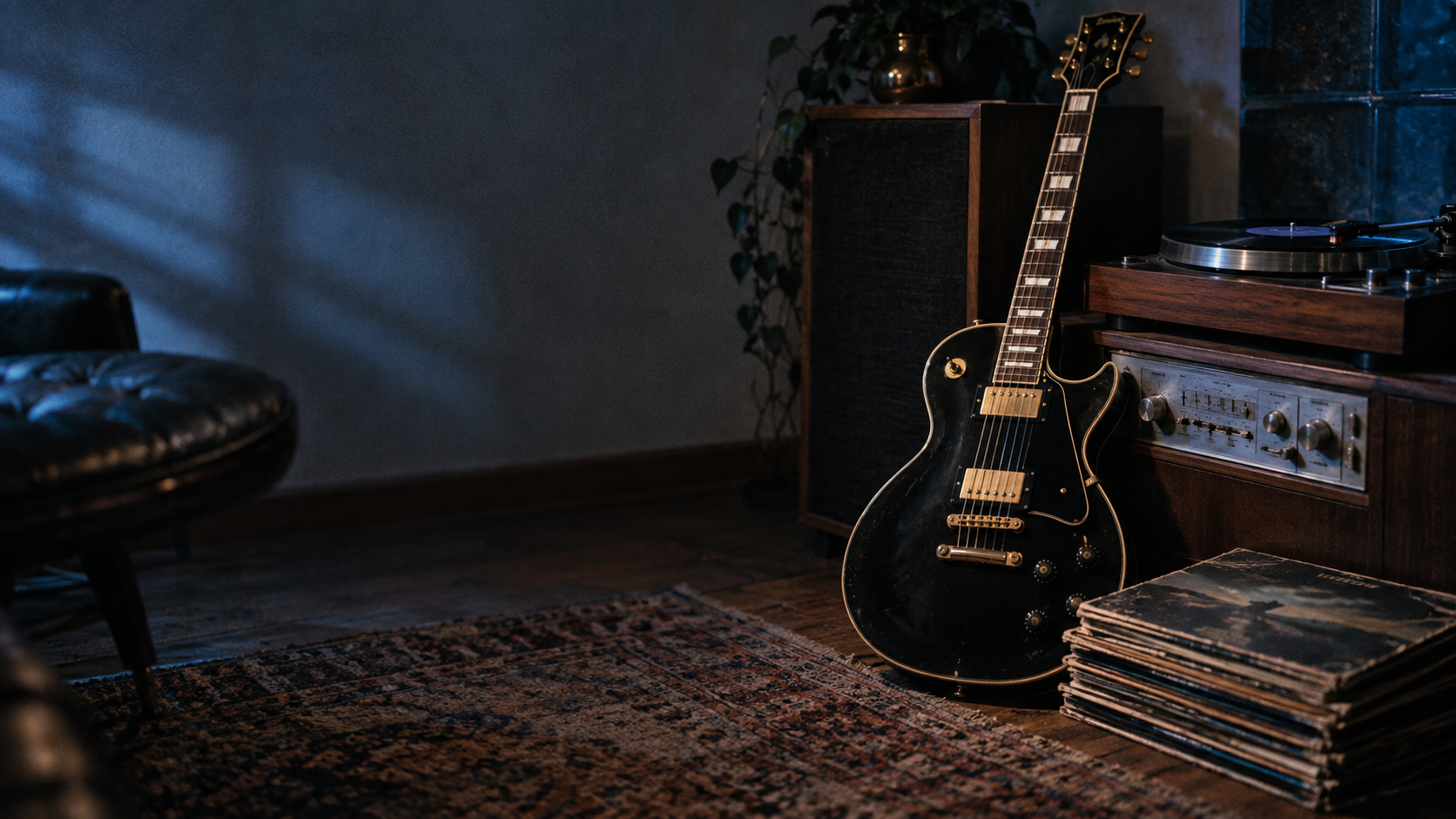 Black electric guitar beside a vintage turntable and records.